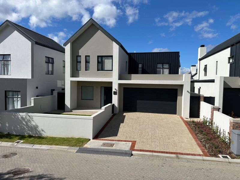 Modern double-story residential home featuring a paved driveway, integrated double garage, and contemporary architectural finishes with a clean, well-maintained facade.