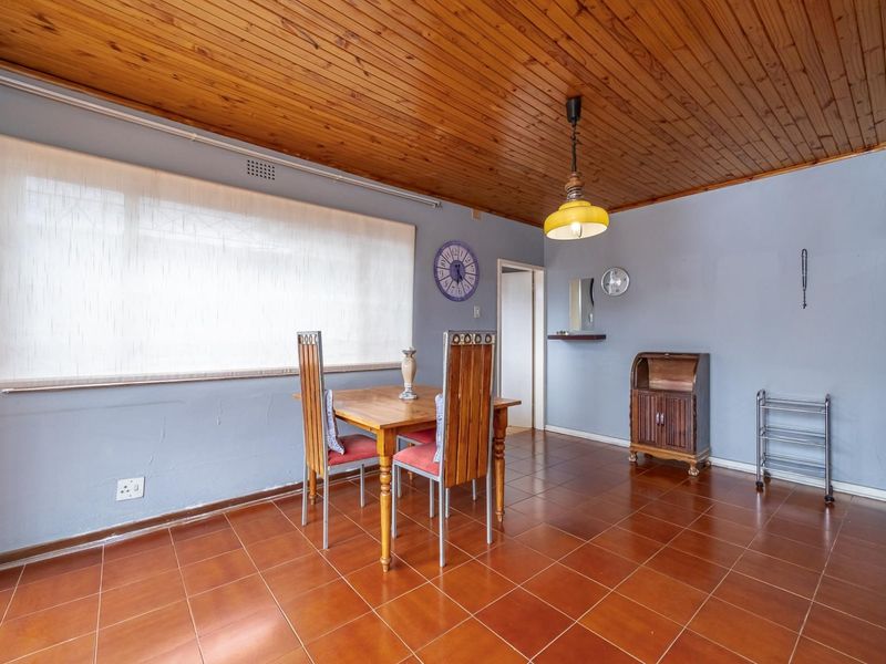 Dining area featuring a timber tongue and groove ceiling, ceramic tiled flooring, and a pendant light fixture.