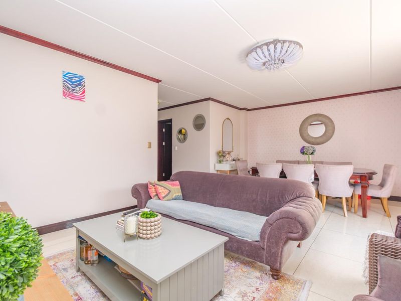 An open-plan living and dining area featuring tiled flooring and neutral wall finishes, providing a versatile space for relaxation and entertaining.