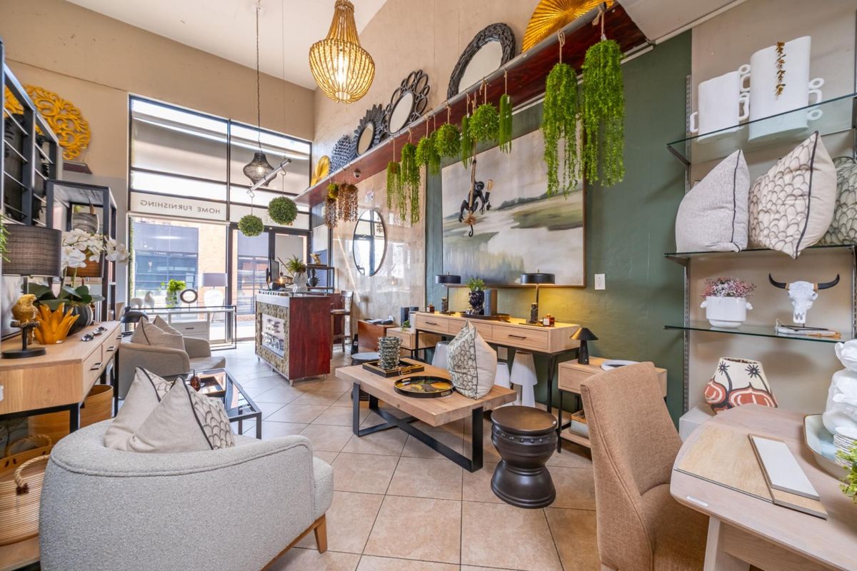 A well-lit retail showroom space featuring high ceilings, large display windows, tiled flooring, and integrated glass shelving units for product presentation.