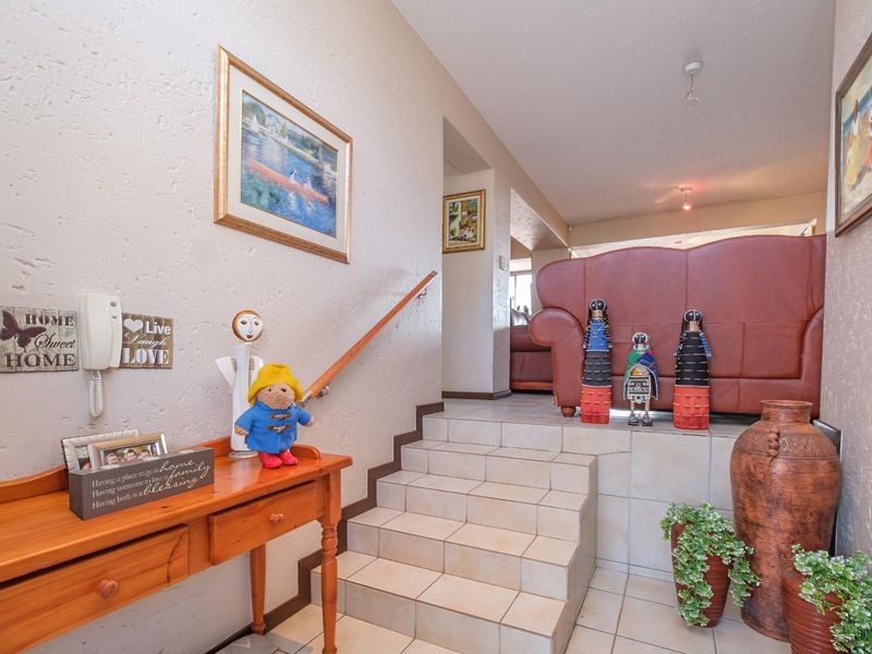 Entrance area featuring a tiled staircase with a wooden handrail, leading up to the main living space with textured wall finishes.