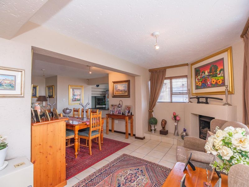 Open-plan living and dining area featuring tiled flooring and a built-in fireplace, creating a comfortable and connected space for daily living.