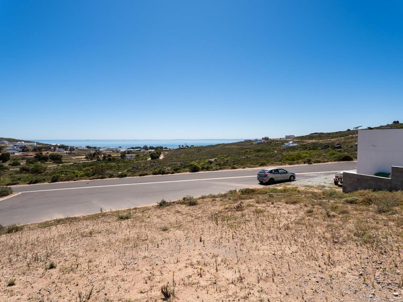 A wide-angle view of the vacant residential land overlooking the coastal landscape and nearby road.
