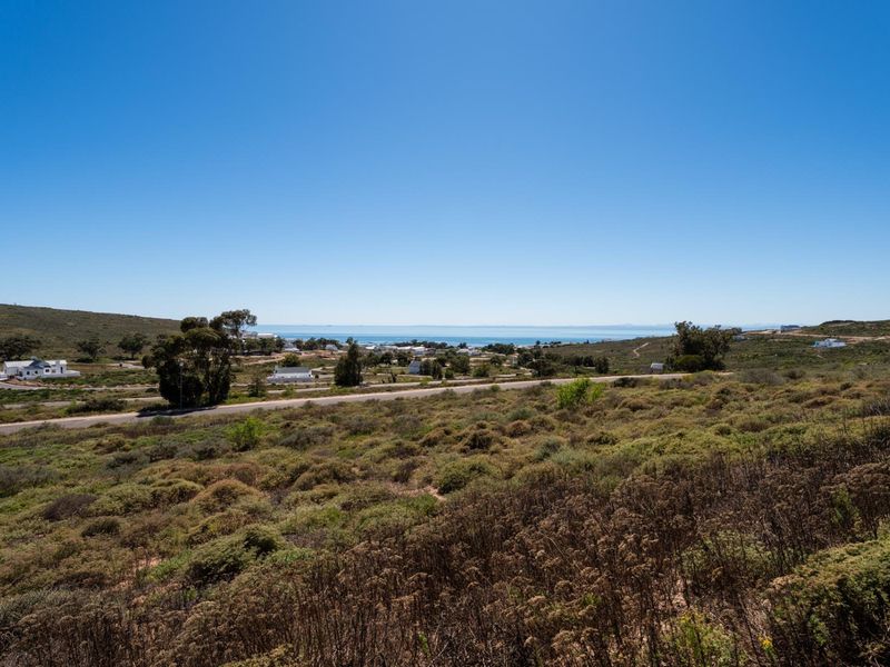 A scenic elevated view overlooking the surrounding coastal landscape and natural vegetation, capturing the horizon and distant sea.