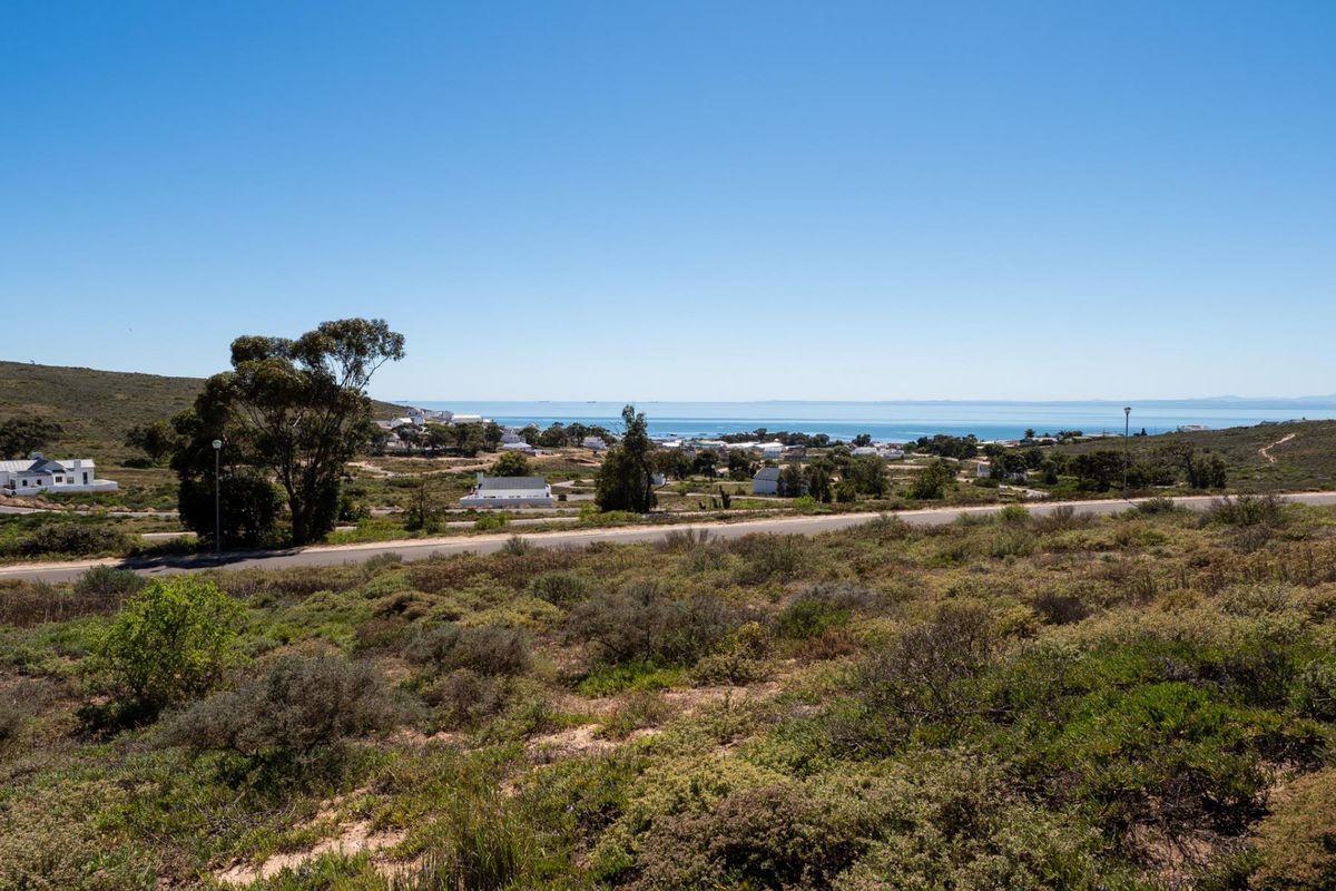 A scenic elevated view overlooking the coastal landscape, surrounding residential area, and the ocean in the distance.