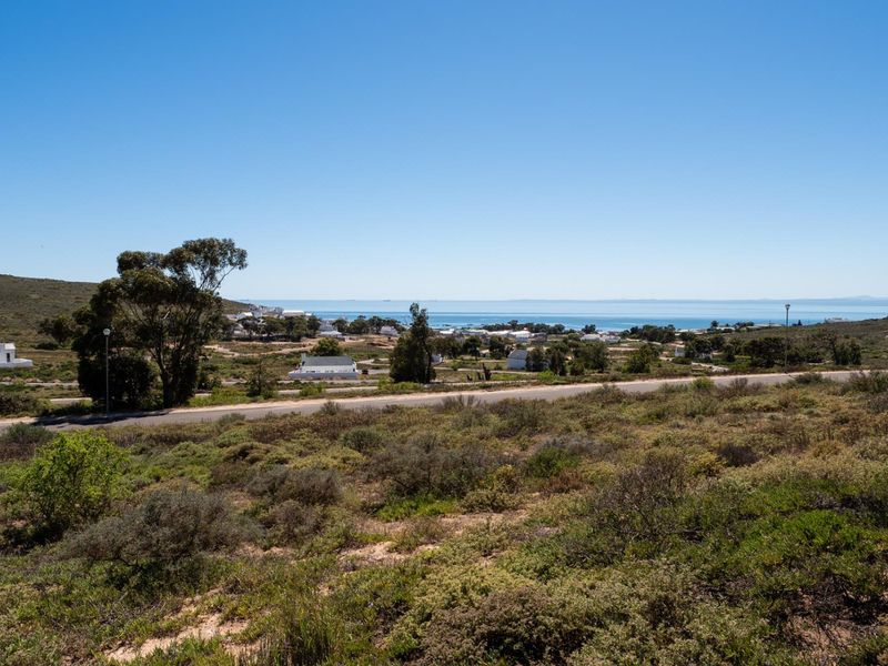 A scenic elevated view overlooking the coastal landscape, surrounding residential area, and the ocean in the distance.