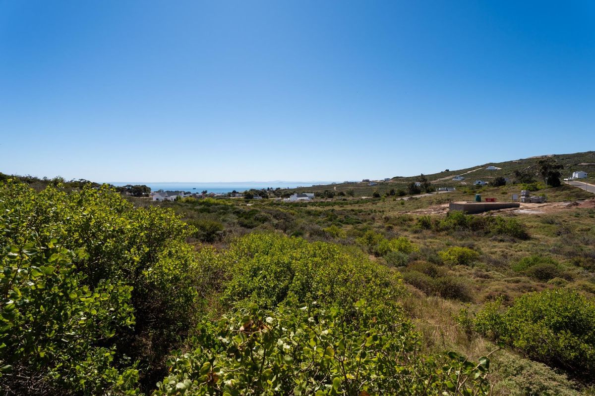A scenic view of the surrounding coastal landscape and natural vegetation, showcasing the open terrain of the vacant residential land.