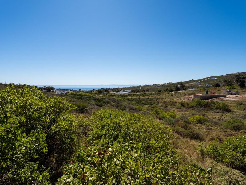A scenic view of the surrounding coastal landscape and natural vegetation, showcasing the open terrain of the vacant residential land.
