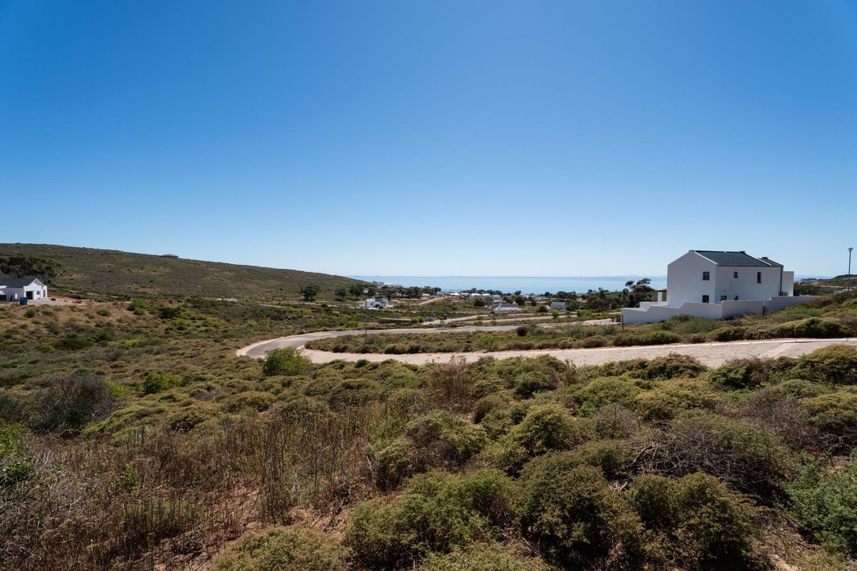 A scenic view overlooking the surrounding coastal landscape, natural vegetation, and local residential development with a clear horizon.