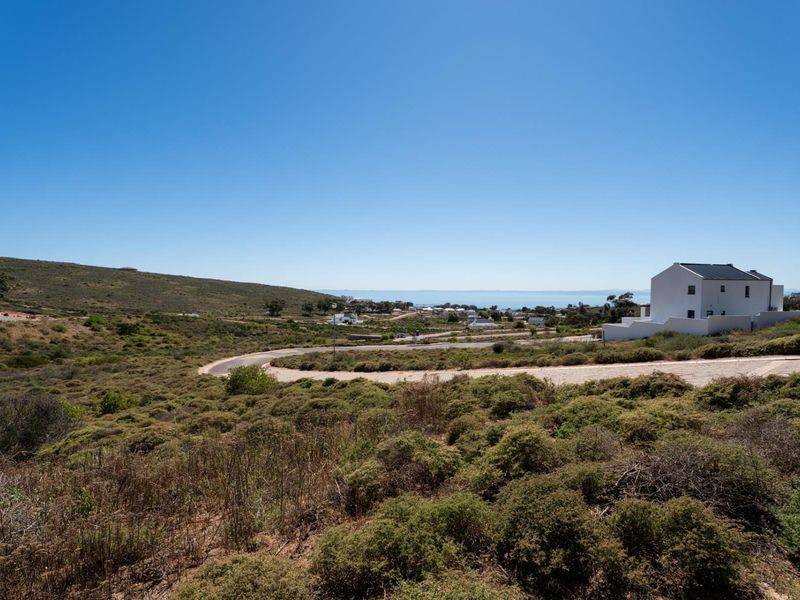 A scenic view overlooking the surrounding coastal landscape, natural vegetation, and local residential development with a clear horizon.