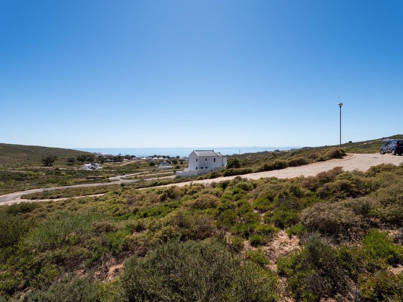 A scenic elevated view of the surrounding landscape, coastal area, and local residential development, showcasing the property's outlook and neighborhood setting.