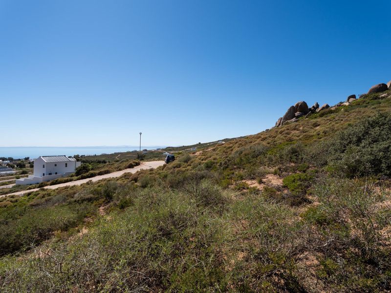 A scenic view of the natural landscape, rocky terrain, and distant coastal horizon from the vacant residential land.