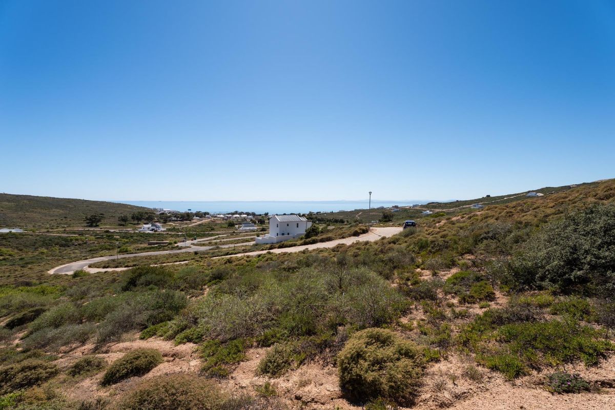 A wide-angle view of the vacant residential land, showcasing the natural landscape, surrounding topography, and distant coastal scenery.