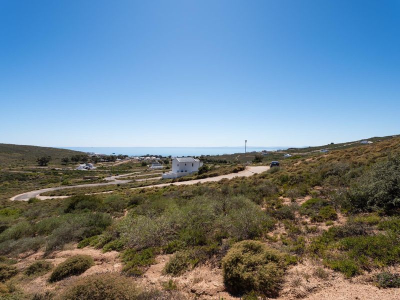A wide-angle view of the vacant residential land, showcasing the natural landscape, surrounding topography, and distant coastal scenery.