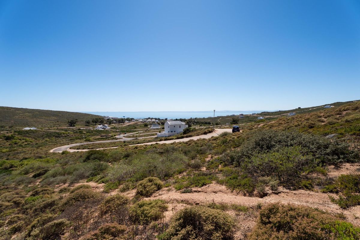 A wide-angle view of the surrounding coastal landscape and natural terrain, showcasing the open space and distant sea horizon.