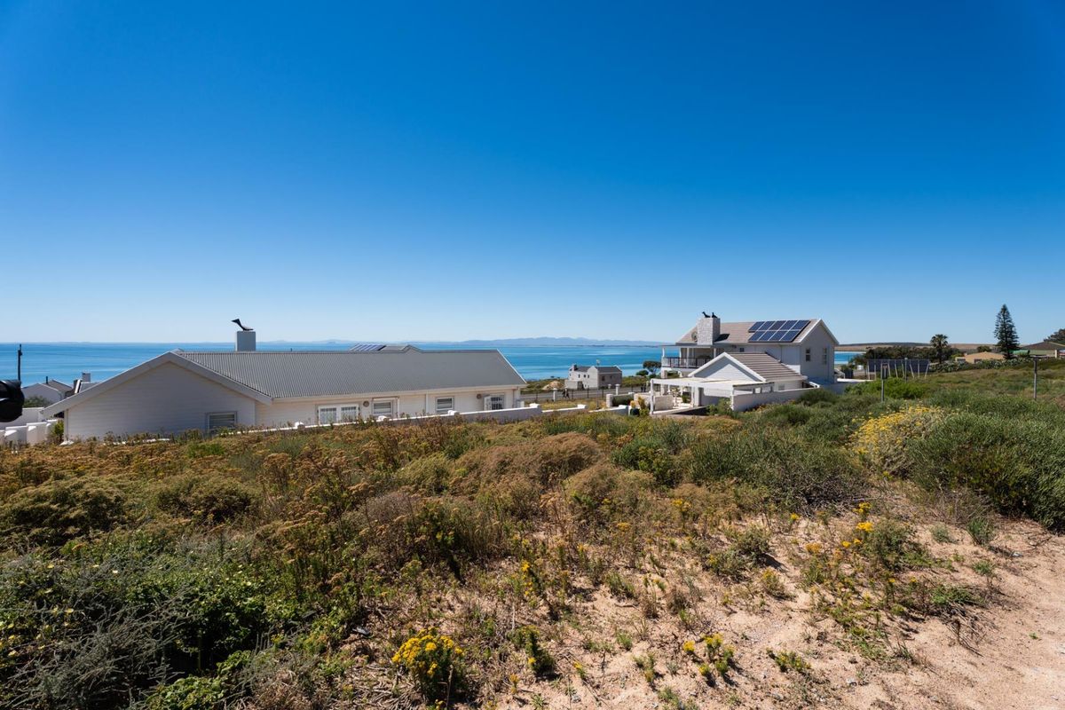 A scenic view of the coastal landscape and ocean, showcasing the surrounding residential neighborhood and natural terrain.