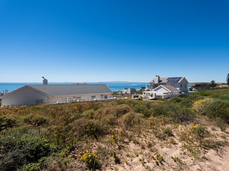 A scenic view of the coastal landscape and ocean, showcasing the surrounding residential neighborhood and natural terrain.