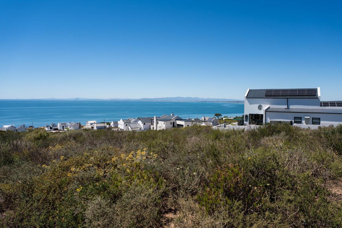 A scenic view overlooking the coastline and ocean from the vacant residential land, showcasing the surrounding neighborhood and natural landscape.