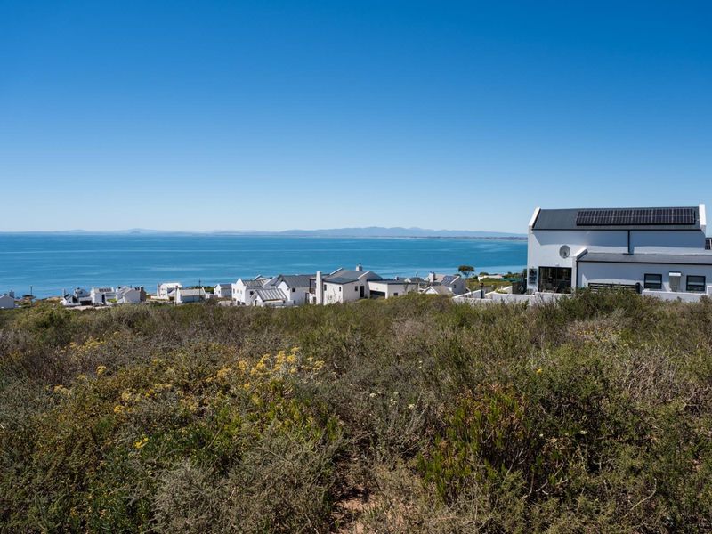 A scenic view overlooking the coastline and ocean from the vacant residential land, showcasing the surrounding neighborhood and natural landscape.