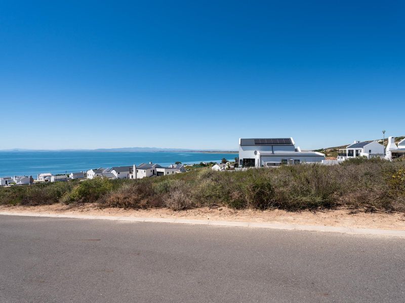 A scenic view of the coastline and residential neighborhood from the street level, showcasing the coastal landscape and surrounding properties.