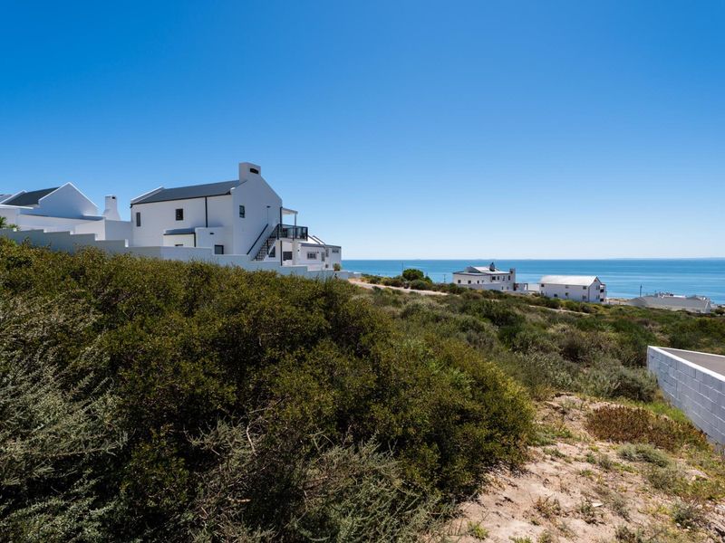 A scenic view of the coastal residential area, showcasing the surrounding landscape and nearby properties with ocean views.