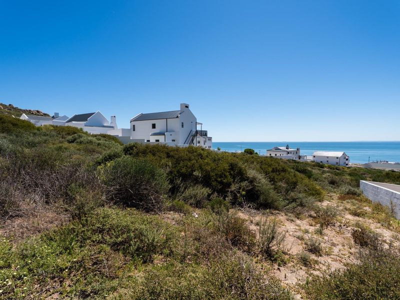 A scenic view of the coastal landscape and surrounding residential properties, highlighting the natural terrain and proximity to the ocean.