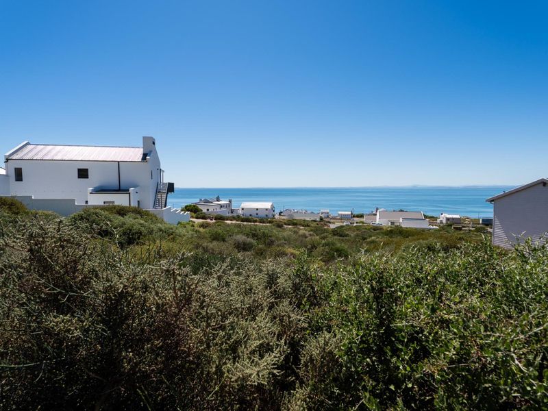 A scenic view overlooking the coastal landscape and ocean, showcasing the surrounding residential area and natural vegetation.
