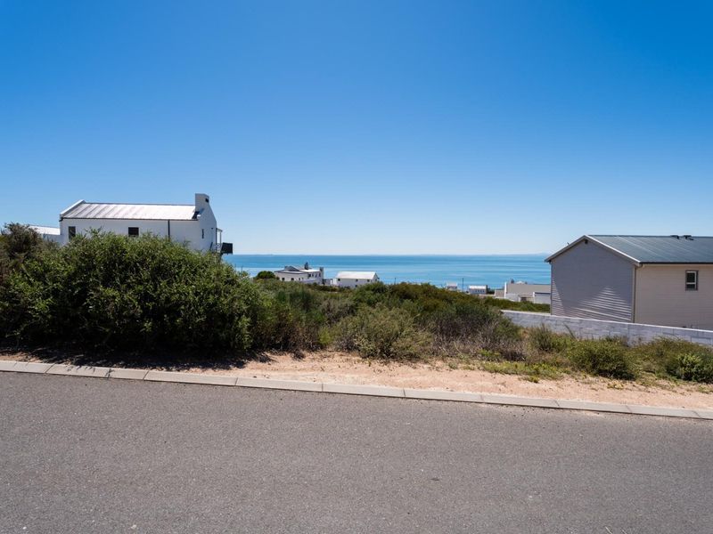 A clear view of the ocean and coastal landscape from the street level of the vacant residential property.