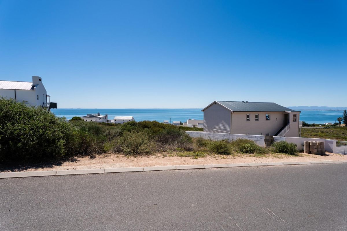 A clear view of the ocean and surrounding coastal landscape from the street level of this vacant residential property.