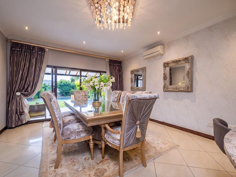 Elegant dining room featuring tiled flooring, textured wallpaper, a crystal chandelier, and sliding glass doors providing access to the outdoor patio area.