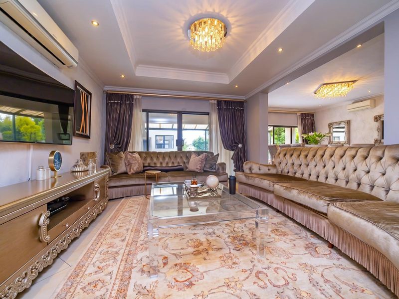 Spacious living room featuring a recessed ceiling with elegant lighting, tiled floors, and large sliding glass doors leading to the outdoor area.