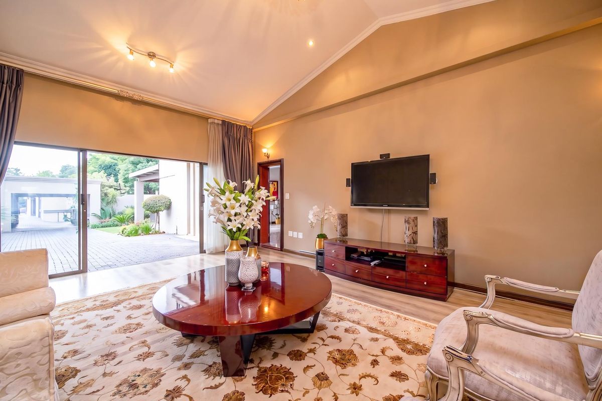 Spacious living room featuring a high vaulted ceiling, recessed lighting, and large sliding glass doors providing seamless access to the outdoor patio area.