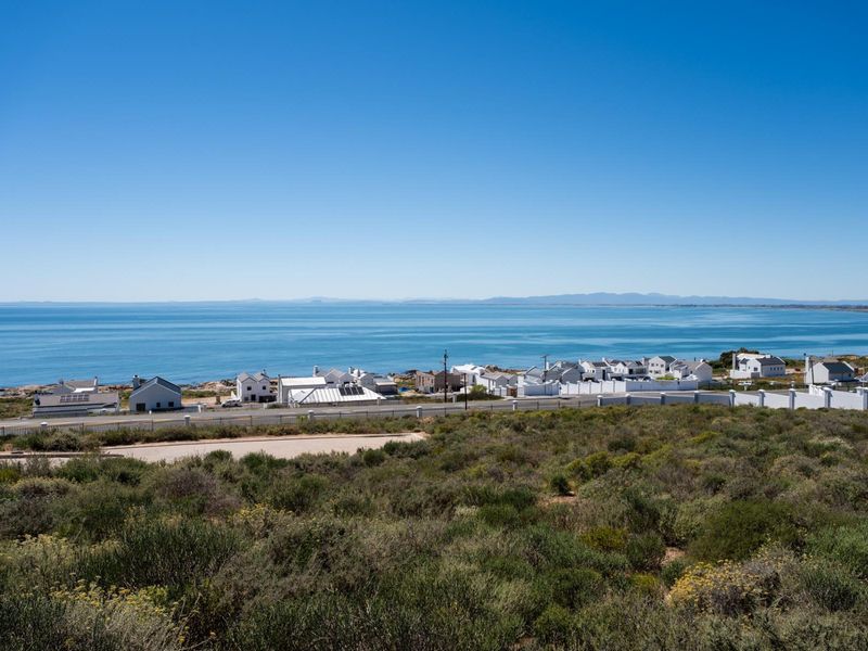 A scenic elevated view overlooking the coastline, ocean, and surrounding residential neighborhood.