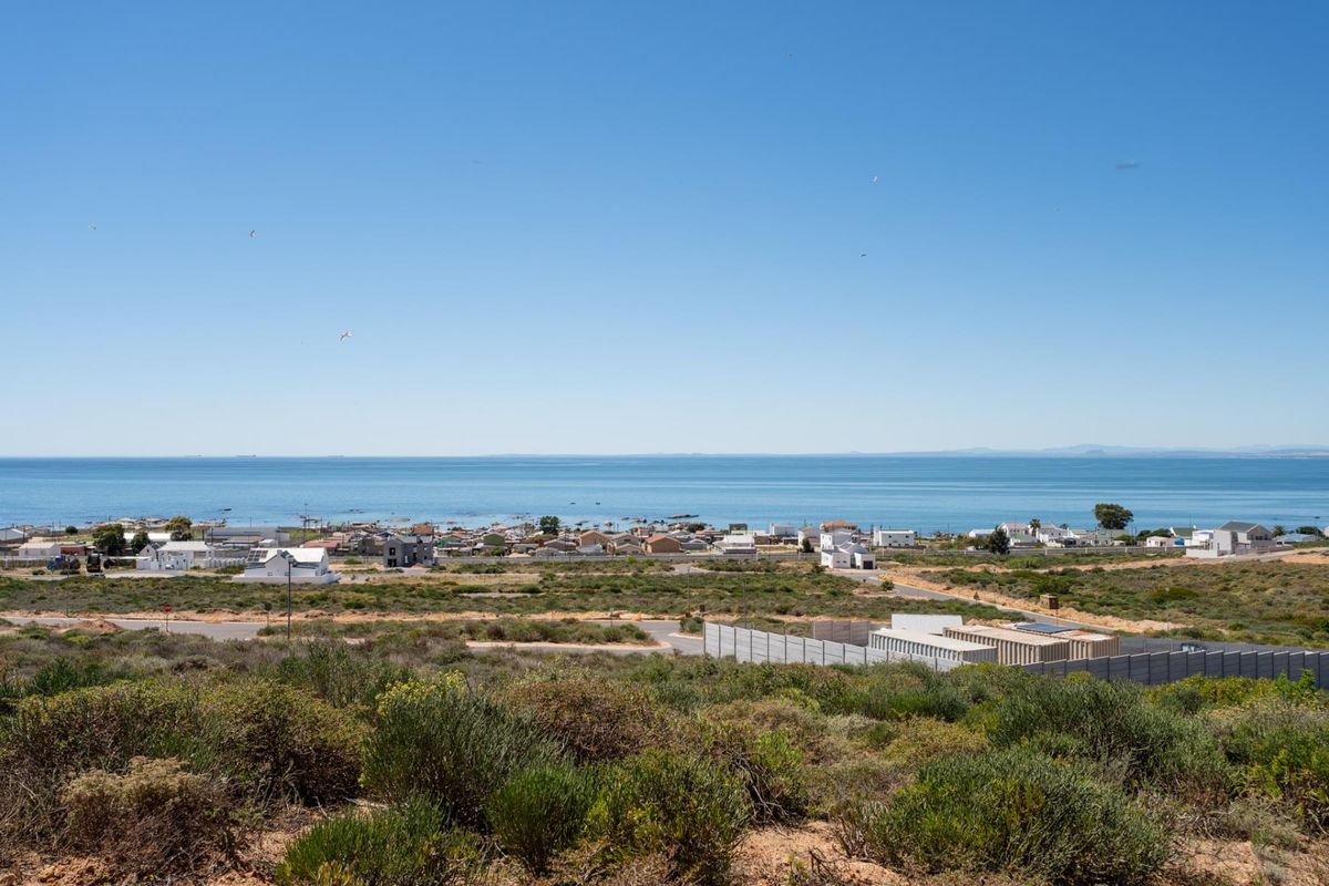 A scenic elevated view overlooking the coastal landscape, residential area, and the ocean horizon.