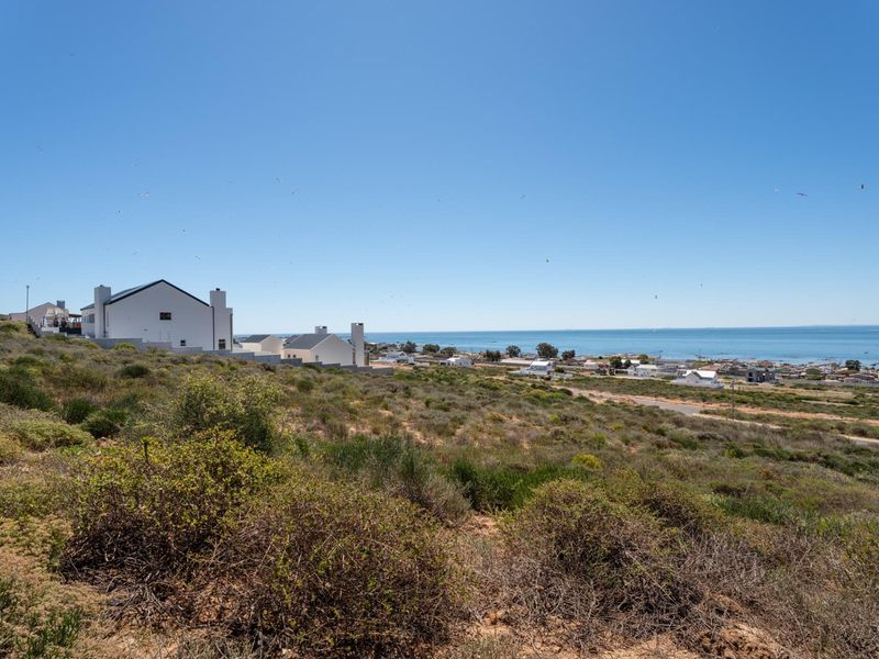 A scenic view of the coastal landscape and surrounding residential area, showcasing the natural terrain and proximity to the ocean.