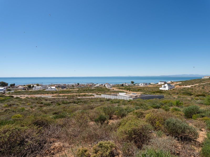 A wide-angle view of the coastal landscape and ocean, showcasing the surrounding residential area and natural terrain.