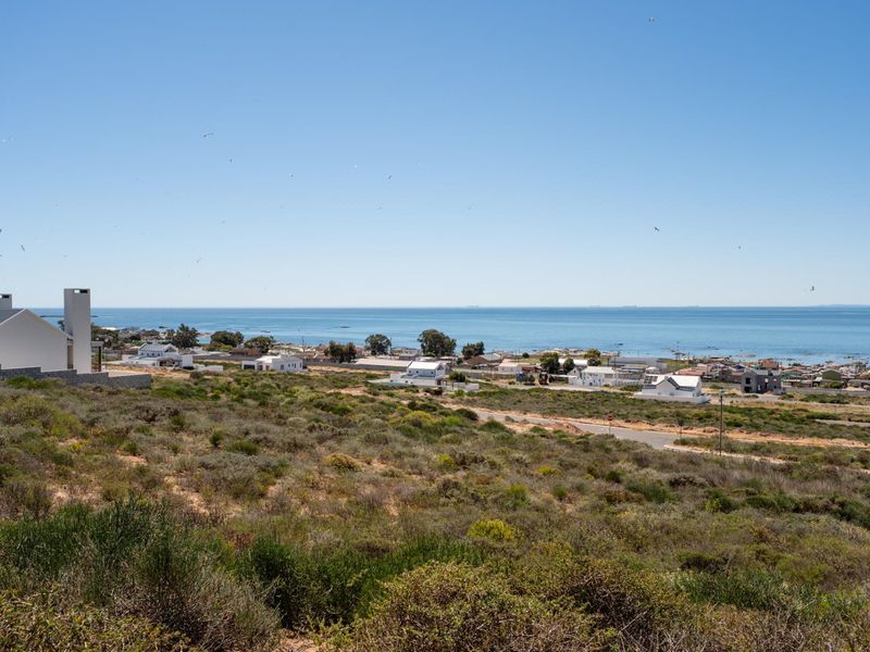 A scenic elevated view overlooking the coastal landscape, surrounding residential neighborhood, and the ocean horizon.