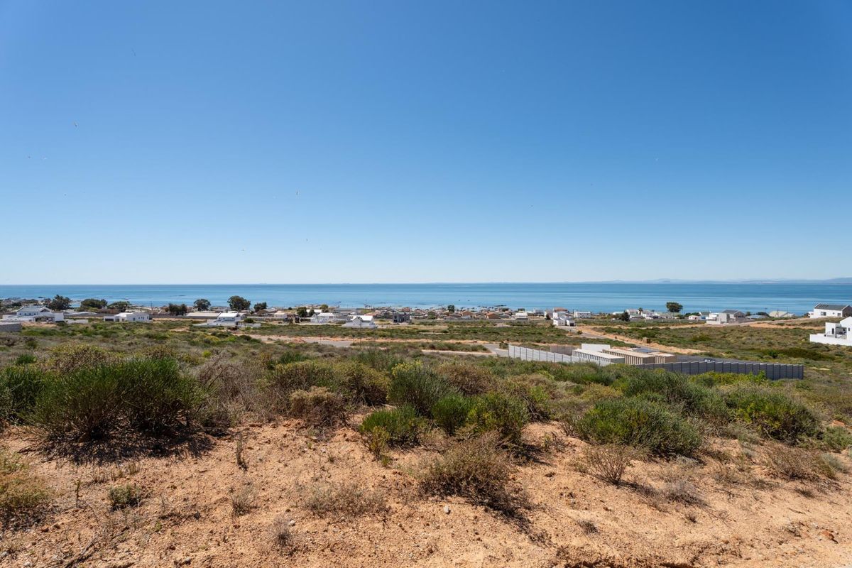 A scenic elevated view overlooking the coastal landscape and ocean, showcasing the natural terrain and surrounding residential area.