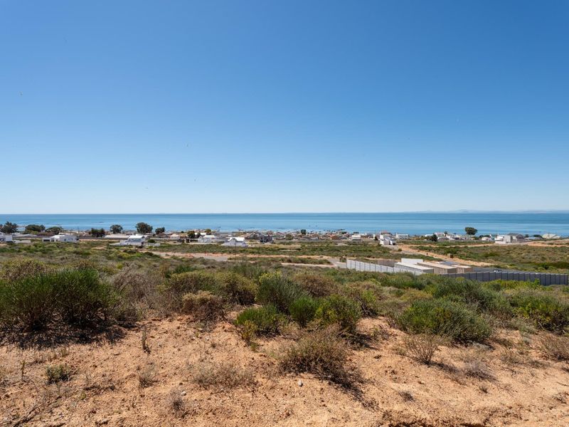 A scenic elevated view overlooking the coastal landscape and ocean, showcasing the natural terrain and surrounding residential area.