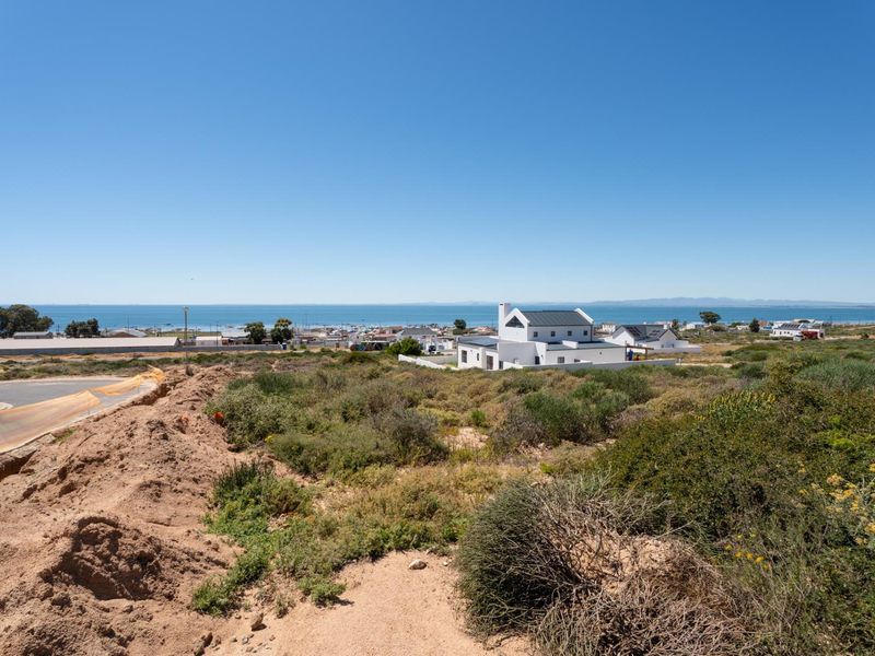 A scenic elevated view overlooking the coastal landscape and ocean, showcasing the surrounding residential area and natural terrain.
