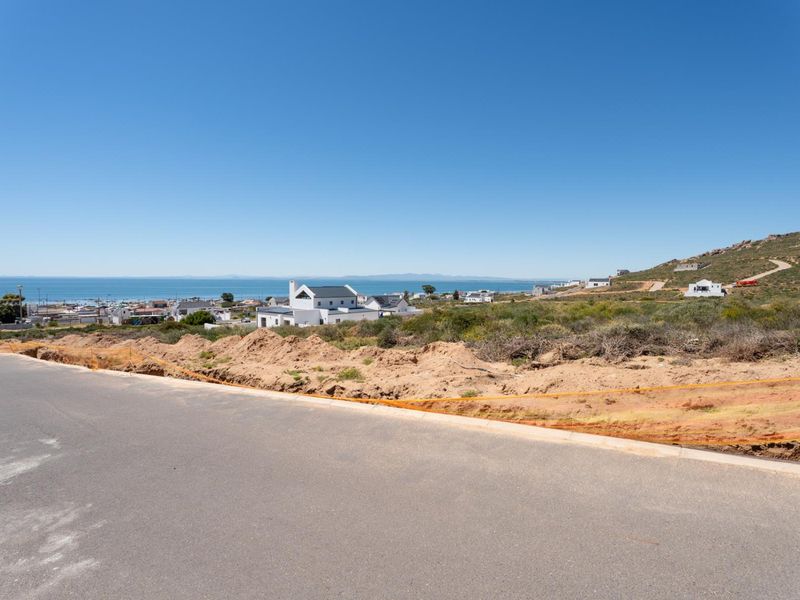 A view from a vacant residential plot overlooking the surrounding coastal landscape and neighborhood.