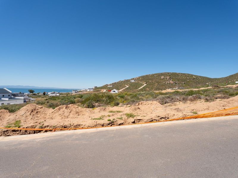 A scenic view of the coastal hillside and surrounding residential landscape from the perspective of the vacant residential land.