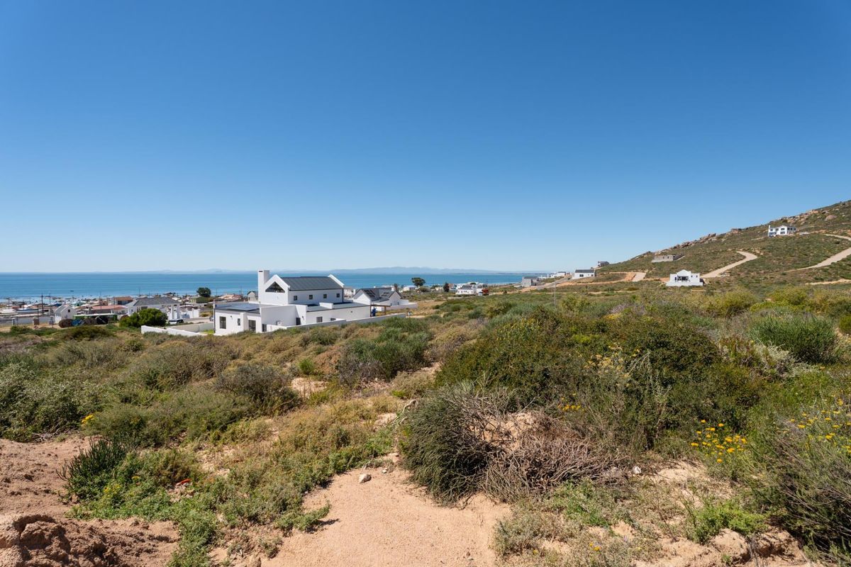 A scenic elevated view overlooking the coastal landscape, surrounding residential properties, and the ocean in the distance.