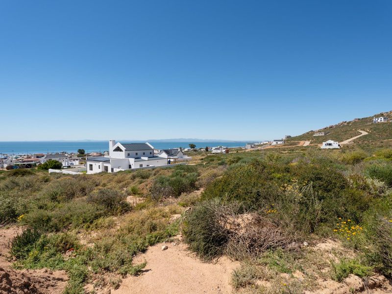 A scenic elevated view overlooking the coastal landscape, surrounding residential properties, and the ocean in the distance.