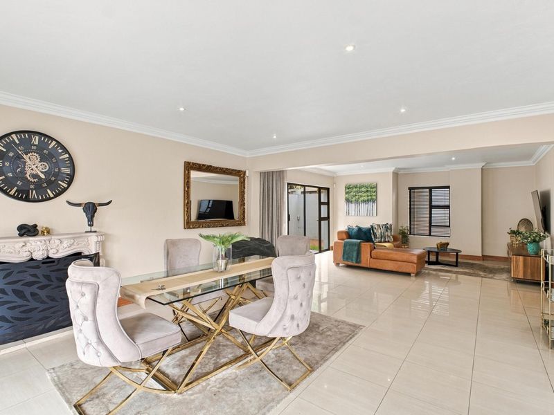 Spacious open-plan living and dining area featuring polished tile flooring, recessed lighting, and a decorative fireplace mantel, creating a bright and inviting atmosphere.