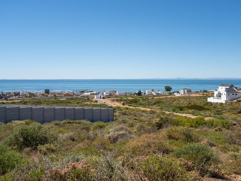 A scenic elevated view overlooking the coastal landscape, surrounding residential properties, and the ocean horizon.
