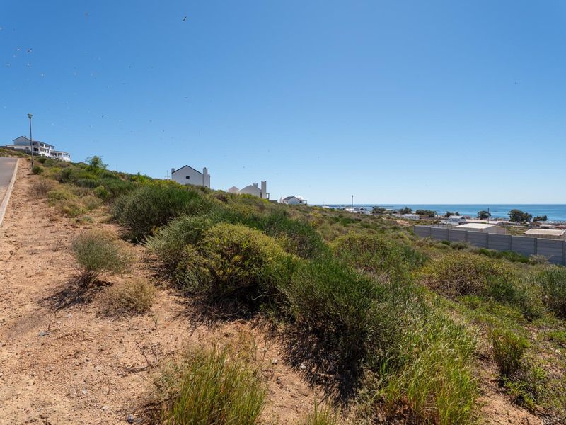 A scenic view of the coastal landscape and surrounding residential area from the vacant residential plot.