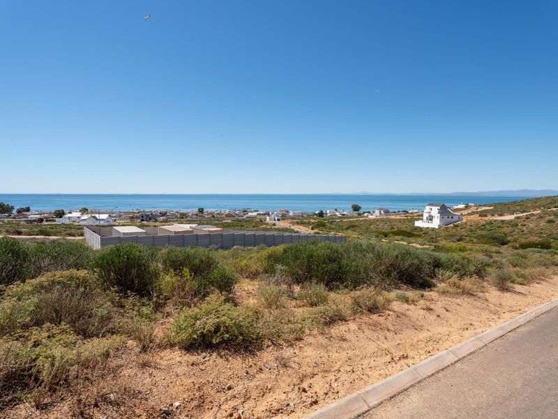 A scenic elevated view overlooking the coastal landscape and ocean, showcasing the surrounding neighborhood and natural terrain.