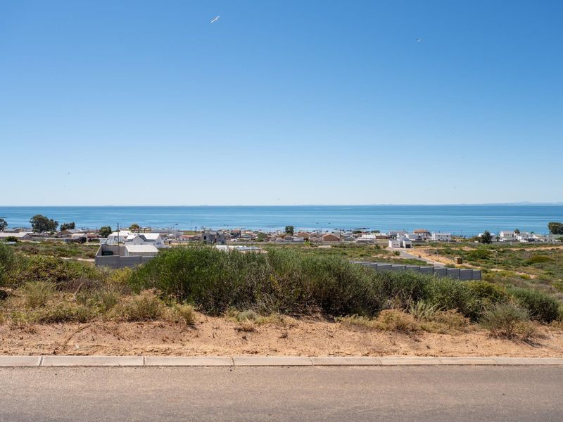 A clear, elevated view of the coastal landscape and ocean from the residential land plot.
