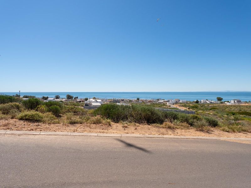 A scenic view overlooking the coastal landscape and ocean from the elevated residential plot.